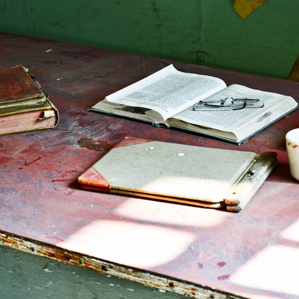 An open book and notebook on a desk