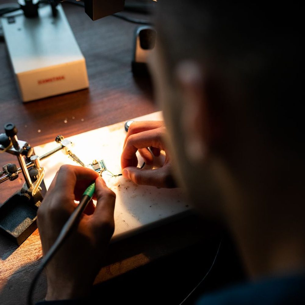 An engineer soldering components at a workbench